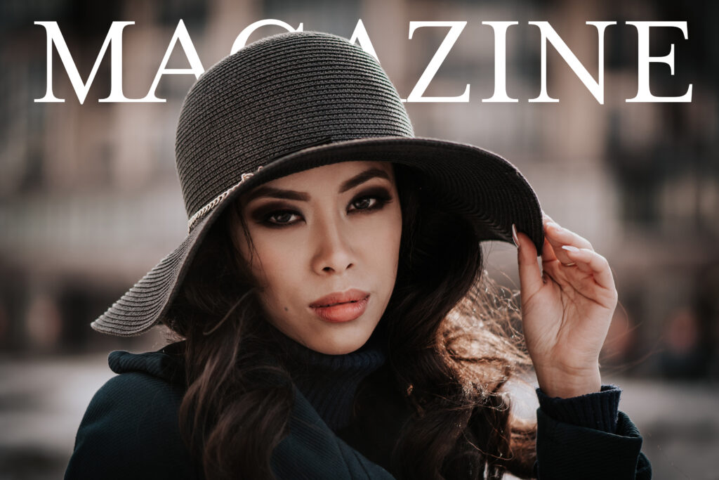 A woman looking straight ahead in a black coat and large-brimmed black sun hat, hand resting on the brim, with the word 'Magazine' partially obscured by her head.